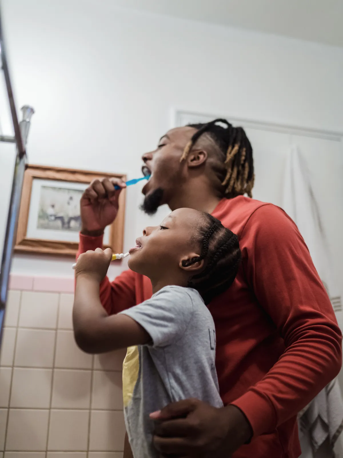 Parent and child brushing teeth together as part of calm paediatric dental care