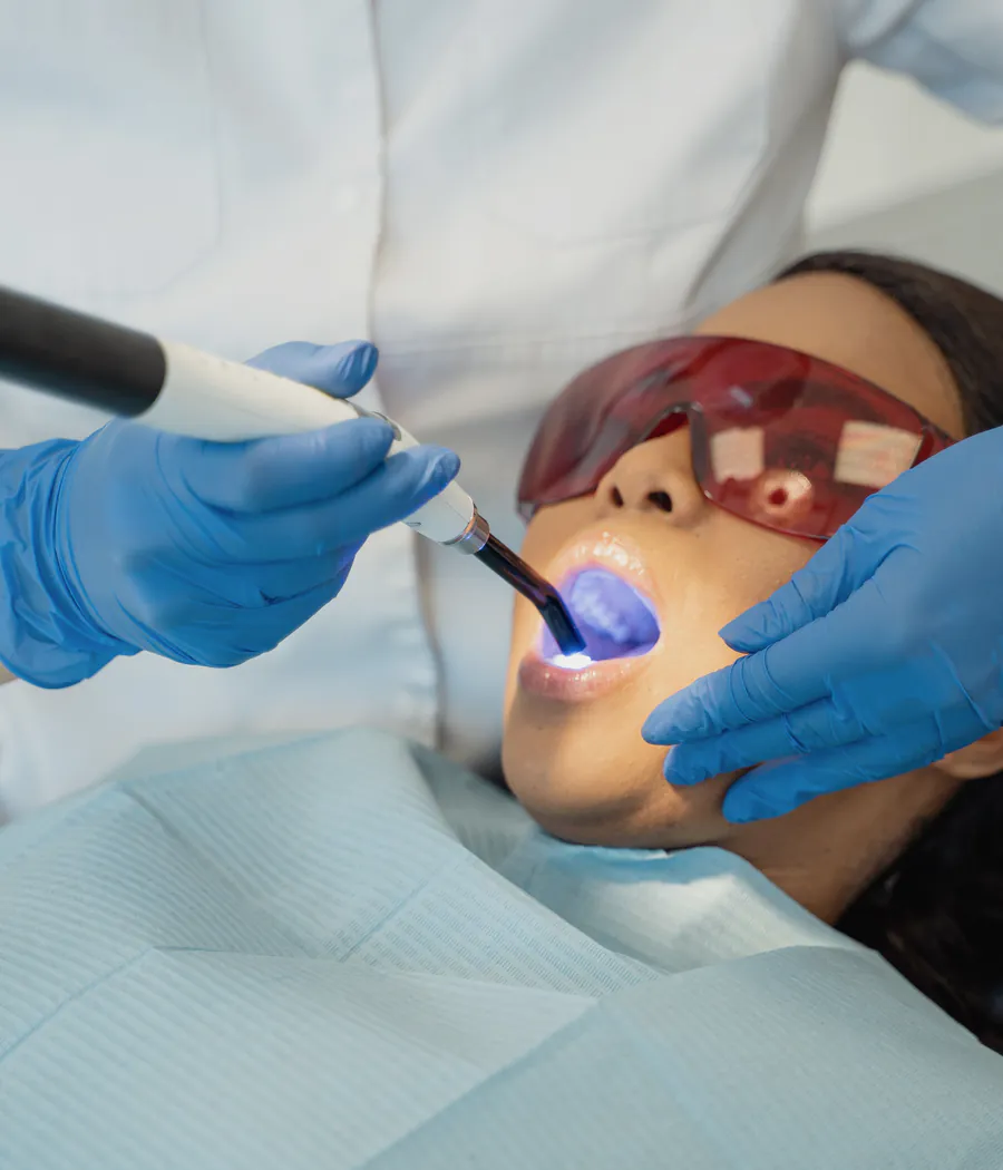 Dentist using a curing light during restorative dental treatment